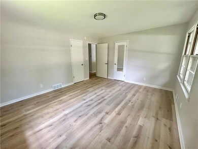 Unfurnished bedroom with baseboards and wood finished floors