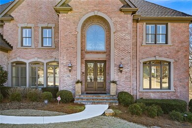 Doorway to property featuring brick siding, roof w
