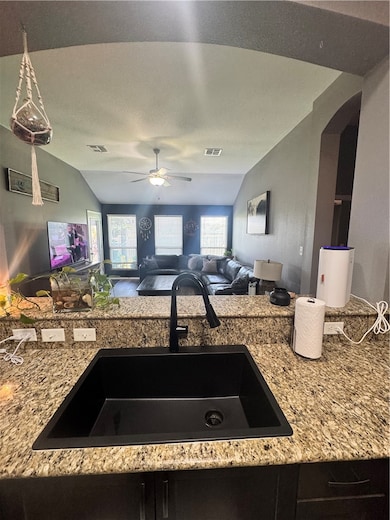 Kitchen featuring lofted ceiling, arched walkways,