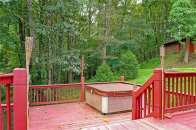 Wooden terrace with a hot tub and a wooded view