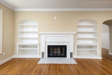 Unfurnished living room with built in shelves, or
