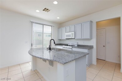 Kitchen with white appliances, light tile patterne