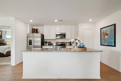 Kitchen featuring a kitchen island with sink, ligh