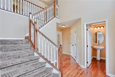 Beautiful 2-Story Entry with Oak Hardwoods and Powder Room away from kitchen.  Leads right into large Open Concept living area.