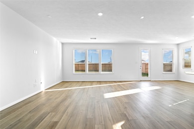 This bright and airy Great Room offers a spacious layout ideal for both relaxing evenings and lively gatherings. Designed for comfort and connection, it features Layton Lake vinyl plank flooring in Driftwood, large windows with blinds, soaring ceilings, recessed lighting, and seamless access to the stunning kitchen—perfect for everyday living and entertaining alike.