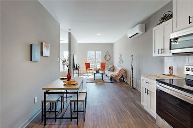 Kitchen with dark wood-type flooring, appliances w