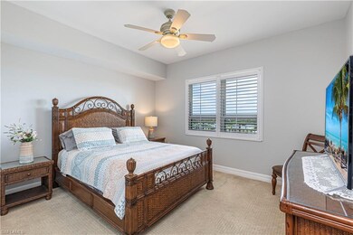 Bedroom with light colored carpet, baseboards, and a ceiling fan