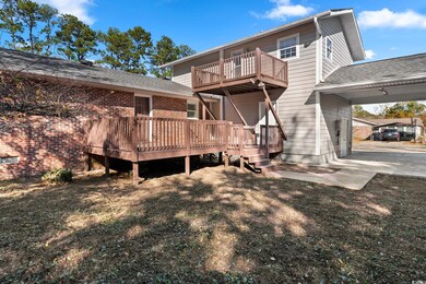 Back of house featuring a lawn and a wooden deck