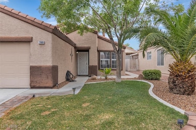 Doorway to property featuring stucco siding, an attached garage, and a tile roof
