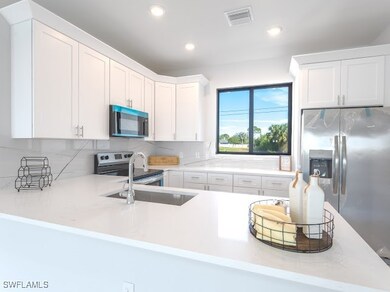 Kitchen with kitchen peninsula, white cabinets, an