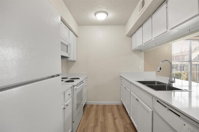 Kitchen featuring sink, white appliances, a textur