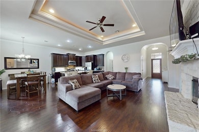 Living room featuring arched walkways, crown moldi