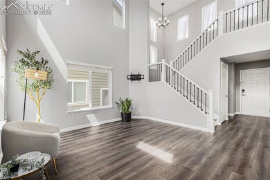 Living area featuring a chandelier, stairway, a towering ceiling, and wood finished floors