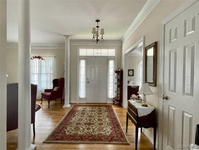 Hardwood floored entryway with a notable chandelie