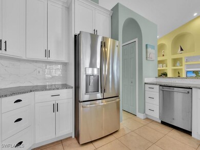 Kitchen with tasteful backsplash, light tile patte