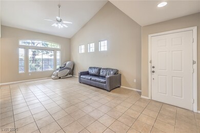 Sitting room with baseboards, high vaulted ceiling