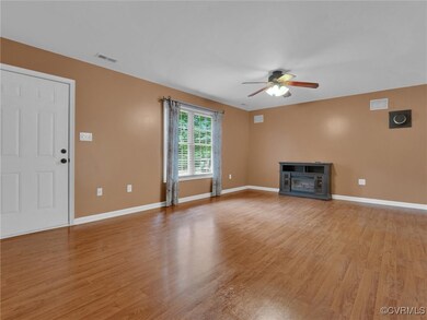 Unfurnished living room featuring ceiling fan, a fireplace, and light wood-type flooring