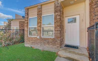 Cozy, single-story brick townhouse with a small fenced front yard, facing the pool offering a relaxing community environment. The exterior offers a welcoming, low-maintenance appeal.