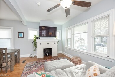 Living room with a wealth of natural light, light wood-type flooring, ceiling fan, and a fireplace