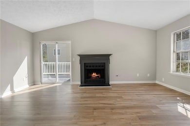 Unfurnished living room featuring vaulted ceiling,