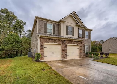 View of front of home with board and batten siding, stone siding, an attached garage, concrete driveway, and a front yard