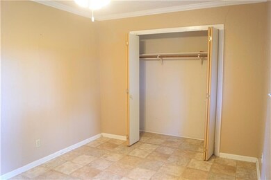 Unfurnished bedroom with crown molding and a clos