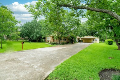 Spacious driveway with attached carport and garage