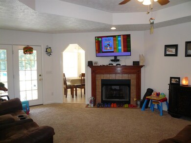 Living room has fireplace and tray ceiling