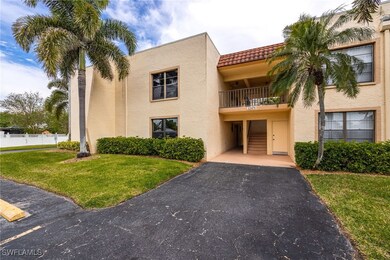 View of building exterior with driveway and fence
