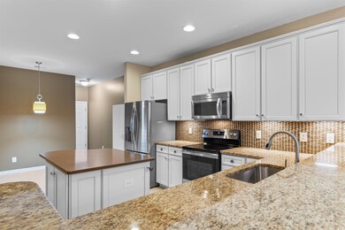 Kitchen featuring white cabinets, stainless steel 