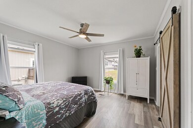 Bedroom with a barn door, light wood finished flo