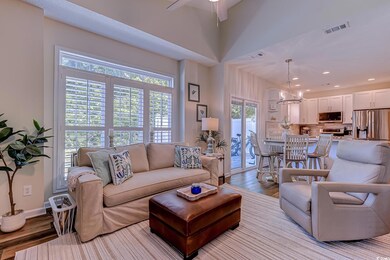 Living area with ceiling fan with notable chandeli