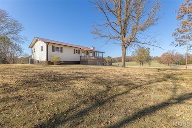 Back of house with a lawn and a chimney