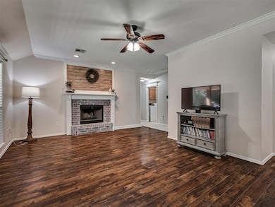 Unfurnished living room with ceiling fan, dark wood-style flooring, ornamental molding, a fireplace, and recessed lighting