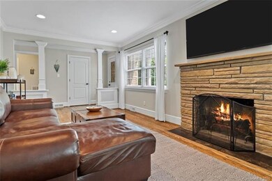 Family room features wood burning fireplace. Photo