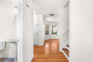 Hallway featuring wood finished floors, a textured ceiling, and stairs