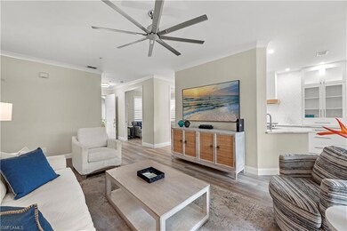 Living room with ornamental molding, wood-type flo