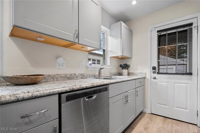 Kitchen with gray cabinets, stainless steel dishwasher, light wood finished floors, light countertops, and recessed lighting