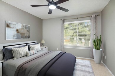 Carpeted bedroom featuring ceiling fan and basebo