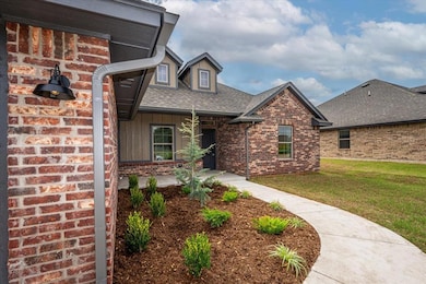View of front facade featuring a porch, brick siding, a front lawn, board and batten siding, and roof with shingles