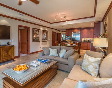 The open-concept great room offers generous seating throughout the living area, seamlessly extending to the adjacent lanai—perfect for relaxing, entertaining, or enjoying the island breeze