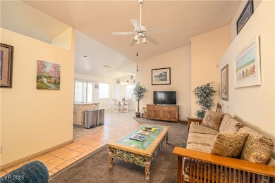 Living area featuring a ceiling fan, light tile pa