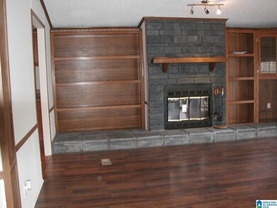 Built in bookshelves flank stone wood burning fire