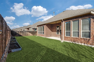 Fenced backyard featuring a patio area and a vegetable garden