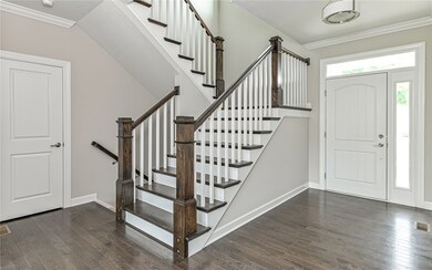 Bright and open foyer with hardwood flooring