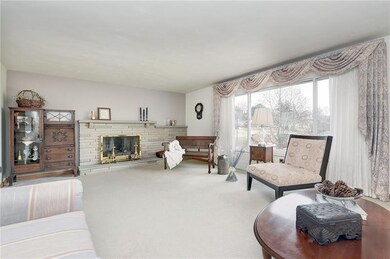 formal living room w/large picture window and custom draperies and gas log fireplace