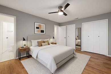 Bedroom with multiple closets, wood finished floo