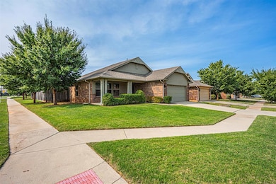 View of front of house featuring brick siding, a front yard, an attached garage, and driveway