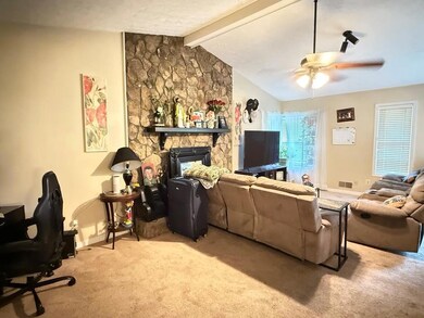 Living area with carpet floors, a ceiling fan, bas