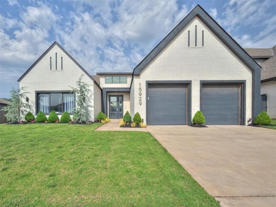View of front of home featuring french doors, driveway, brick siding, and a garage